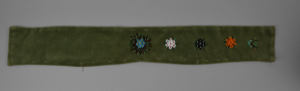 Image of beaded green velvet band , unfinished, possibly for use decorating a hood or parka; or a sampler of beaded designs