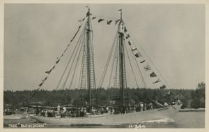 Image of The schooner BOWDOIN, dressed with guests aboard, in the harbor