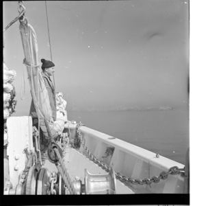 Image of Rutherford Platt standing in bow, looking at fog bank