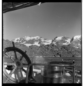 Image of Looking across stern and wheel to coastal mountains with snow