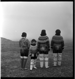 Image: Three Inuit women and a girl in traditional dres, rear view