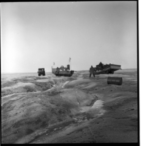 Image of Three vehicles, men and a barrel on Greenland ice cap