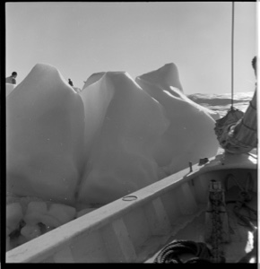 Image of The BOWDOIN tied to a wave-washed iceberg