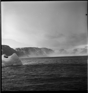 Image of Small iceberg, mist and mountains