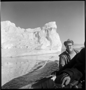 Image of Man sitting by rail, iceberg beyond