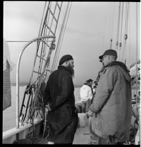 Image of French priest at Pond Inlet on deck with crew