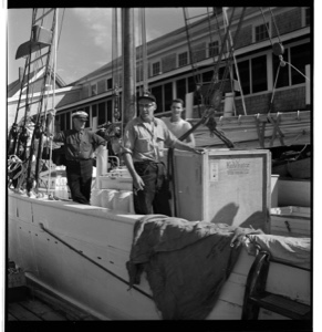 Image of Unloading a Kelvinator from the BOWDOIN. MacMillan standing at rear