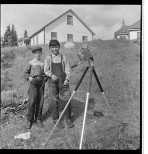 Image of Two "livyer" boys stanging by camera tripod, on a hill