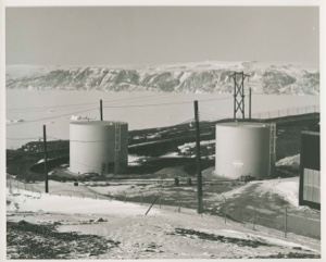 Image of Two large storage tanks; roads; low mountains beyond