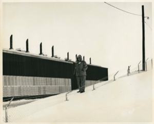 Image of Man standing on snowy slope by building at Thule AFB