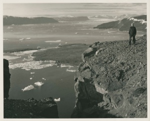 Image of Man standing on low bluff at coast, Thule AFB