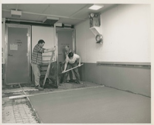 Image: Two men preparing new flooring, Thule AFB