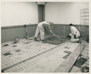 Image: Two men smooth concrete for new floor, Thule AFB