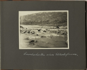 Image: Durchschreiten eines Gletscherflusses [Passing through a glacial river: Two men with back packs ford a rushing stream]