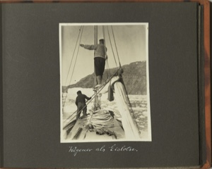 Image: Wegener als eislotse [Wegener as ice pilot: fore deck of small boat and two men. Wegener stands on the boom indicating a direction, wthile the other uses a pole on the ice]