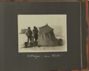 Image of Zeltlager "am Bach" [Tent camp at "The Creek": two men standing by small tent, with supplies]