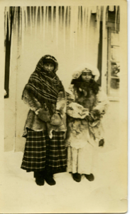 Image: Two Innu Women in Winter Clothing Standing outside Building