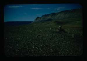 Image: Person sitting on rocky plain