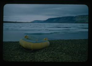Image of Inflatable yellow raft overturned on a rocky coast
