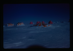 Image of Orange and white tents in snow field.