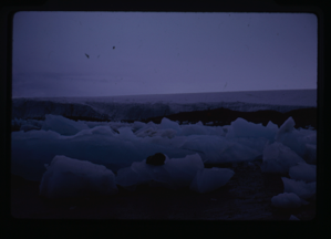 Image: Field of ice near glacier. Large cross in distance.