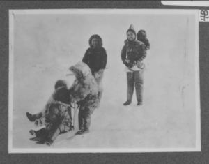 Image of Eskimos - baby and three children, tiny sledge