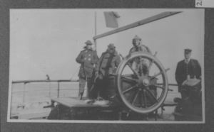 Image: Four crew members standing at a helm