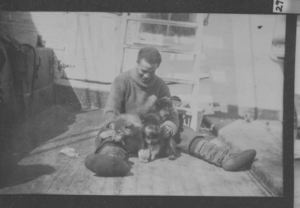 Image of Borup with puppies, on deck