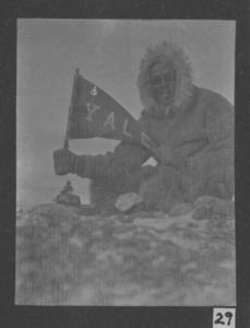 Image: Borup holding Yale pennant, on land