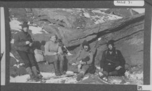 Image of Four men at rest against rocks