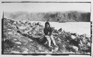 Image of Shoo-e-ging-wa [Suakannguaq Qaerngaaq] with her arms full of flowers. The fiord still covered with ice