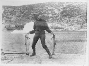 Image of [Man holding 2 fish]