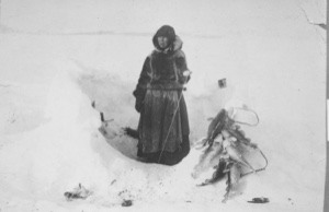 Image of [Eskimo [Inuk] woman fishing through ice]