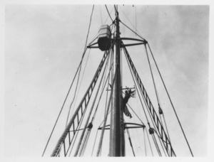 Image of [E. F. McDonald at masthead of Bowdoin to set Chicago Yacht Club pennant.]