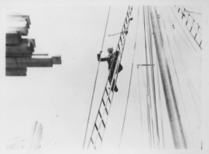 Image: [Donald MacMillan on rigging; lumber on dock]