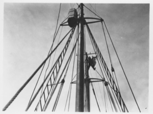Image of [E.F. McDonald in rigging attaching flags, Chicago Yacht Club pennant]