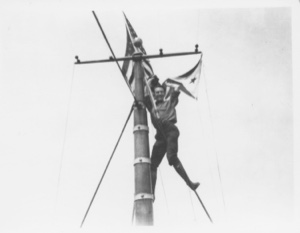 Image: E. F. McDonald at the masthead of the Bowdoin holding Chicago Yacht Club Pennan