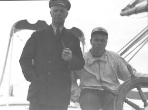 Image of Donald MacMillan and George Murphy at wheel of the Bowdoin
