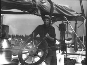 Image of Miriam MacMillan at wheel aboard the Schooner Bowdoin
