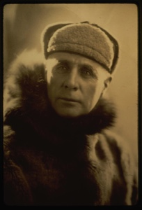 Image of Donald MacMillan in fur parka. Formal portrait.