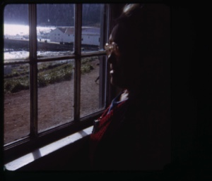 Image of Eskimo [Inuk] woman looking out window