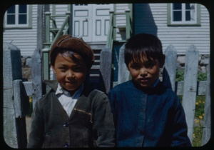 Image of Two Eskimo [Inuit] boys by fence