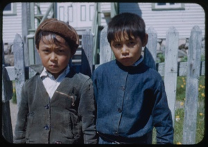 Image of Two Eskimo [Inuit] boys by fence