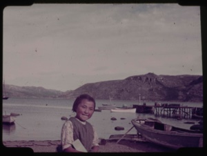 Image: Eskimo [Inuk] girl sitting on boardwalk at beach