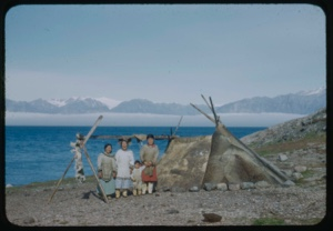 Image of Three Eskimo [Inuit] women and a child by sealskin tent