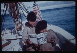Image of Two Eskimo [Inuit] boys on the BOWDOIN looking at ”Etuk, The Eskimo [Inuit] Hunter"”