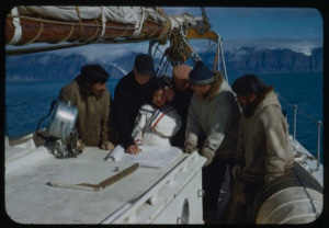 Image of DBM and Eskimos [Inuit] on the Bowdoin studying charts