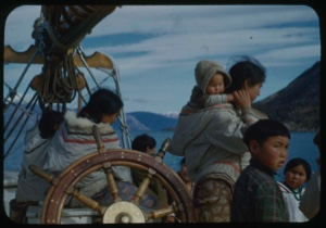 Image of Group of Eskimos [Inuit] by the wheel