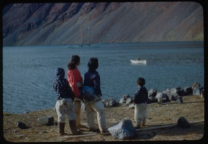 Image of Eskimos [Inuit] watching canoe approaching