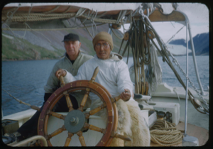 Image of Donald MacMillan and Eskimo [Inuk] man wearing glasses, at wheel